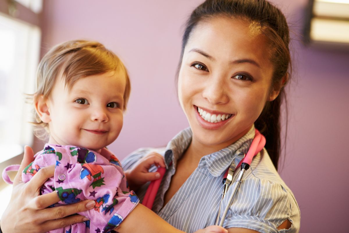 Smiling pediatrician with happy baby