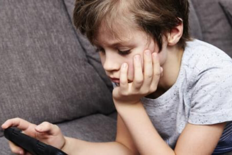 Young person on sofa using a gaming device