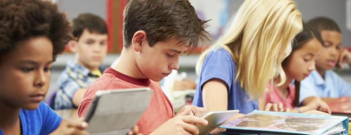 Children in a classroom working on tablet devices