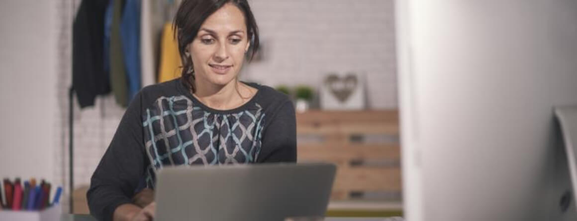 Woman sitting at a desk working on a laptop