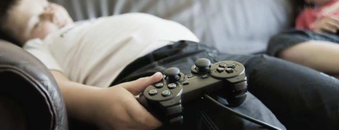 Young boy lying on couch holding a game controller