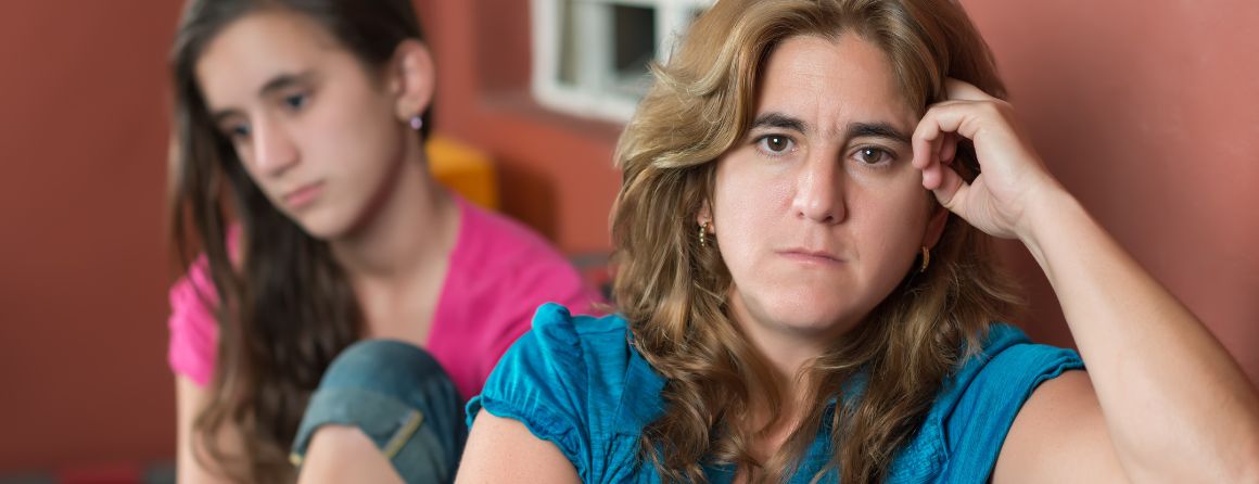 Worried mother and her sad teenage daughter 