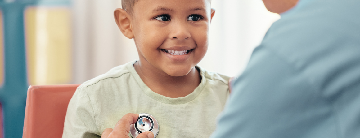 Happy mixed race child getting his heart checked at a clinic by a specialist