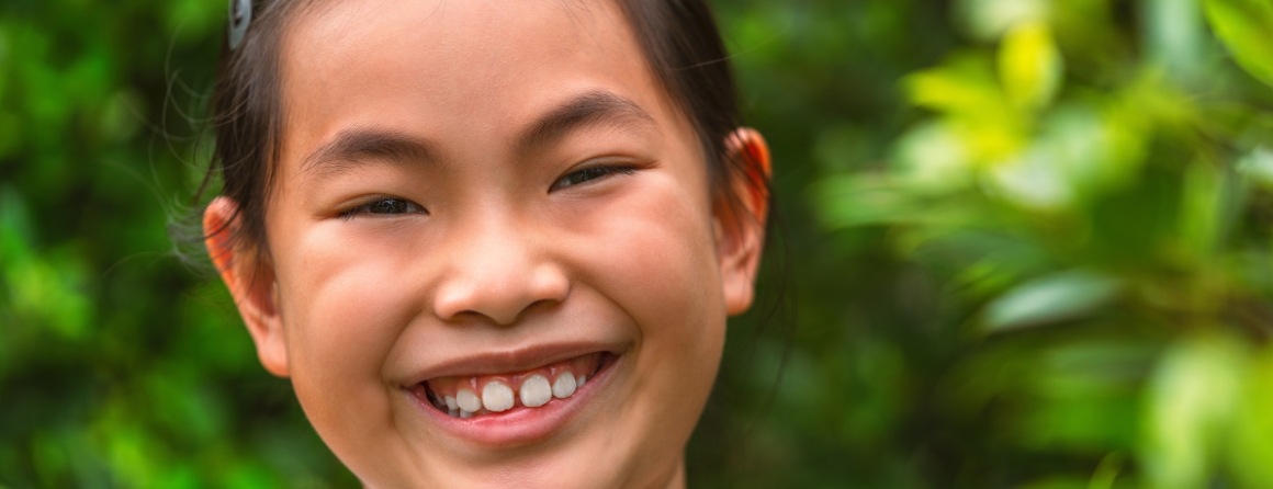 A child smiling showing their teeth