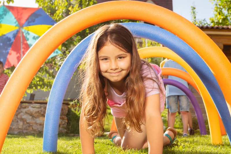 a young girl crawling under play equipment