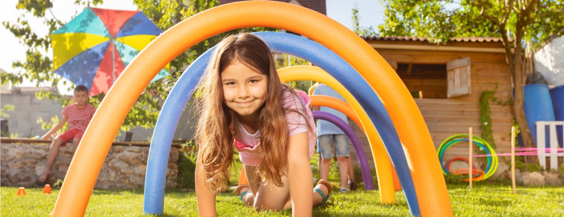 a young girl crawling under play equipment