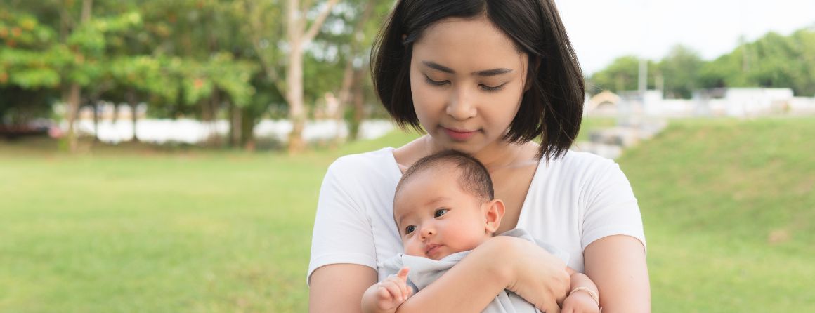 Mother holding baby in a park