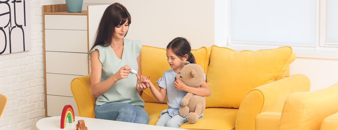 Mother testing young girl's insulin levels due to type 1 diabetes