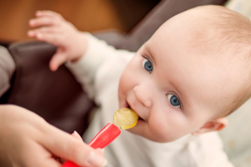 Baby being fed solids