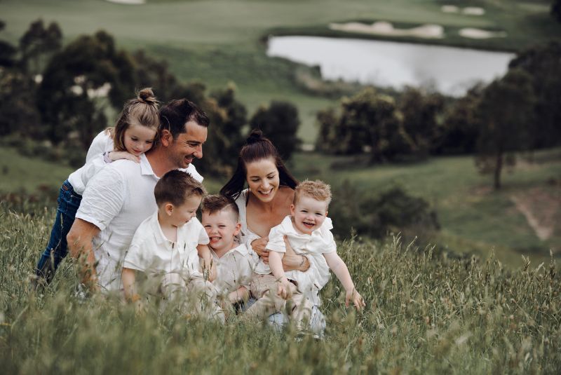 Family sitting on a hill in the countryside
