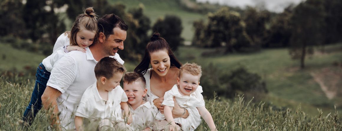 Family sitting on a hill in the countryside