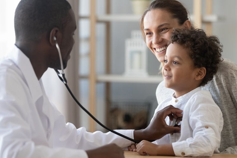 Doctor listening to child's heartbeat