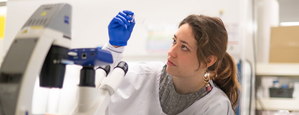 A researcher holding a microscope slide