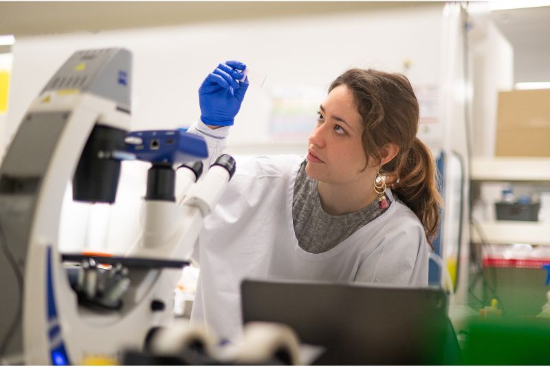 A researcher holding a microscope slide
