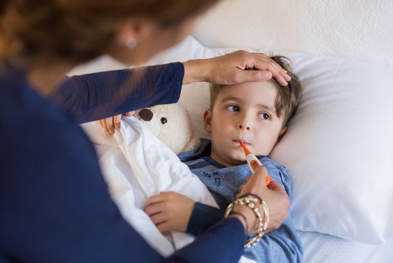 Sick child with a thermometer