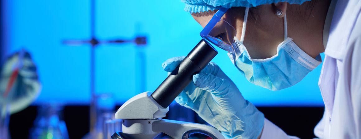 A researcher looking in a microscope