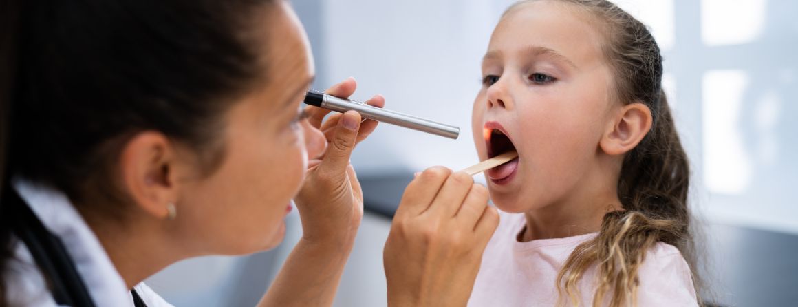 A doctor checks a child for Strep A