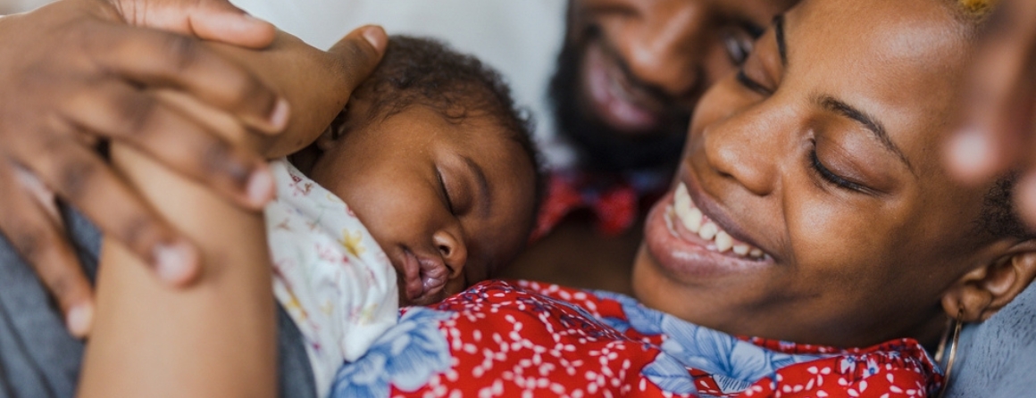 A mother and father holding their baby