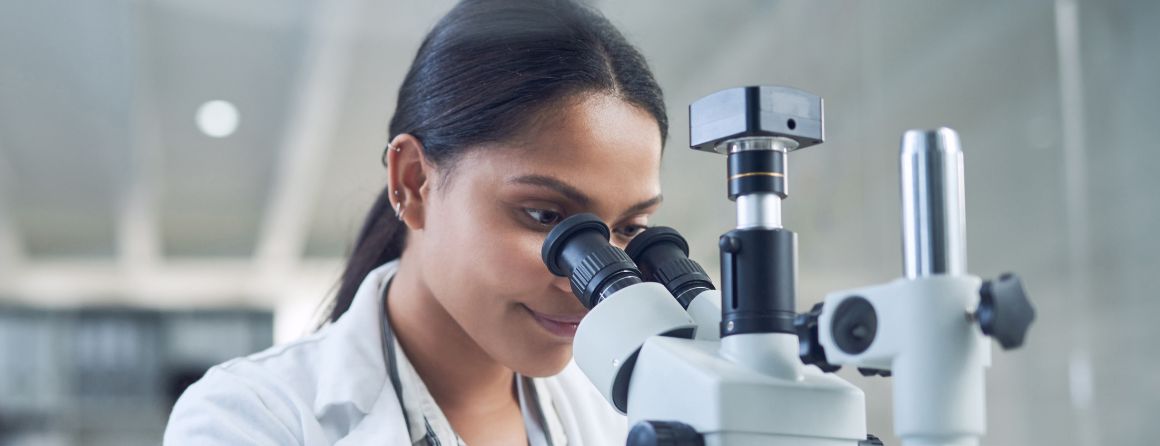 A researcher looking into a microscope