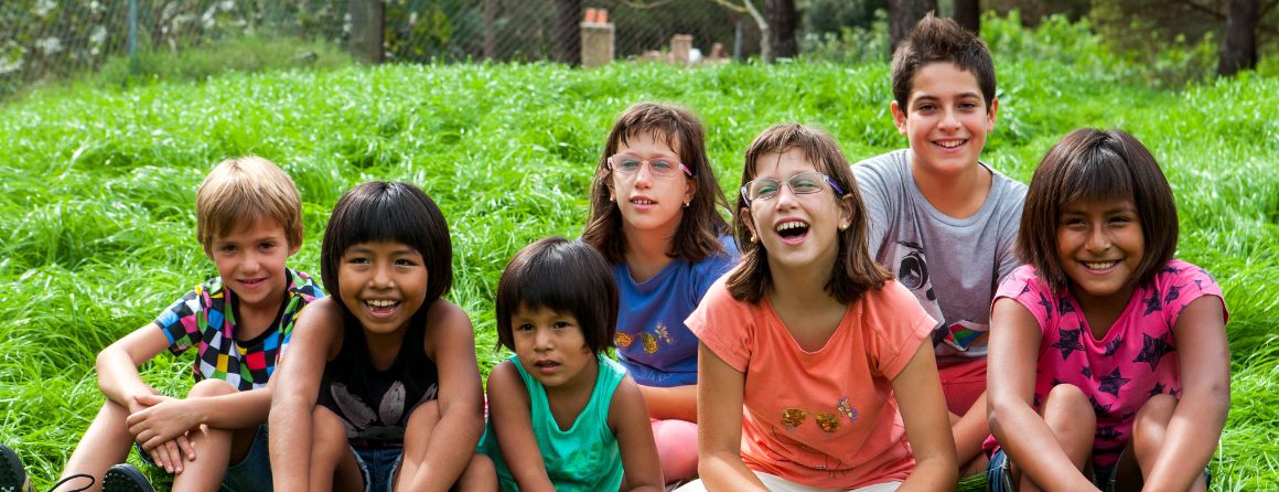 A group of children laughing in the grass