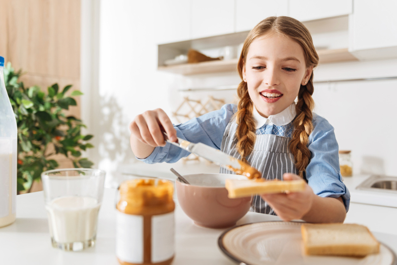 A child eating peanut butter on bread