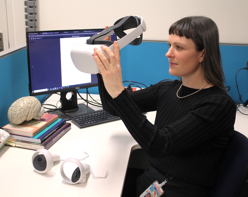 Dr Michelle Tennant holding a VR headset