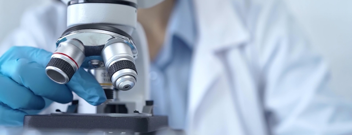 A researcher looking under a microscope