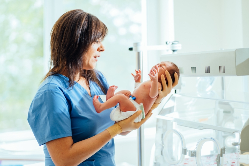 A woman holding a preterm baby
