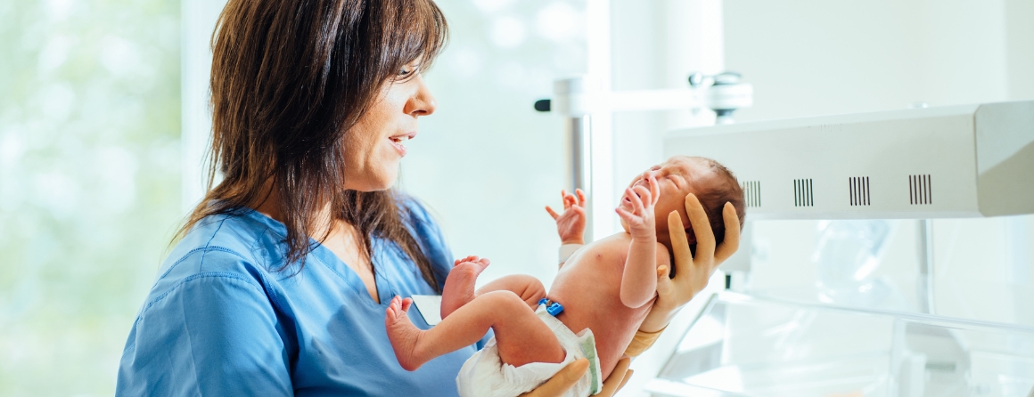 A woman holding a preterm baby