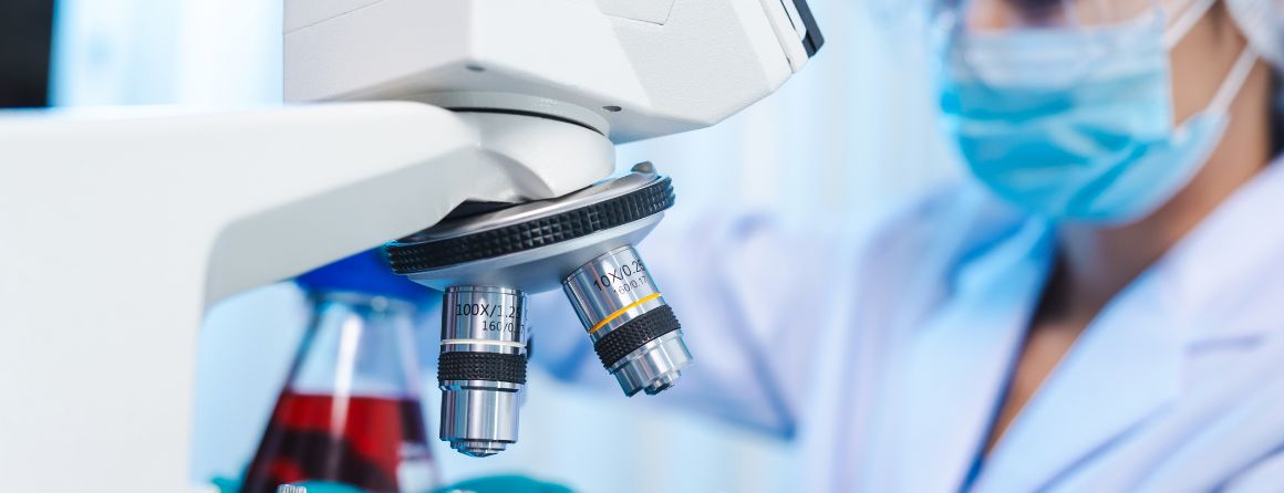 Scientist in the lab with a microscope 