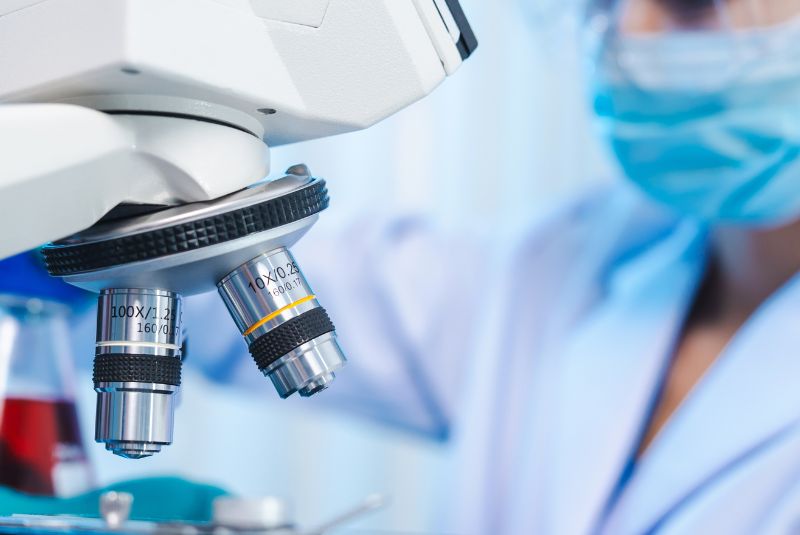 Scientist in the lab with a microscope 
