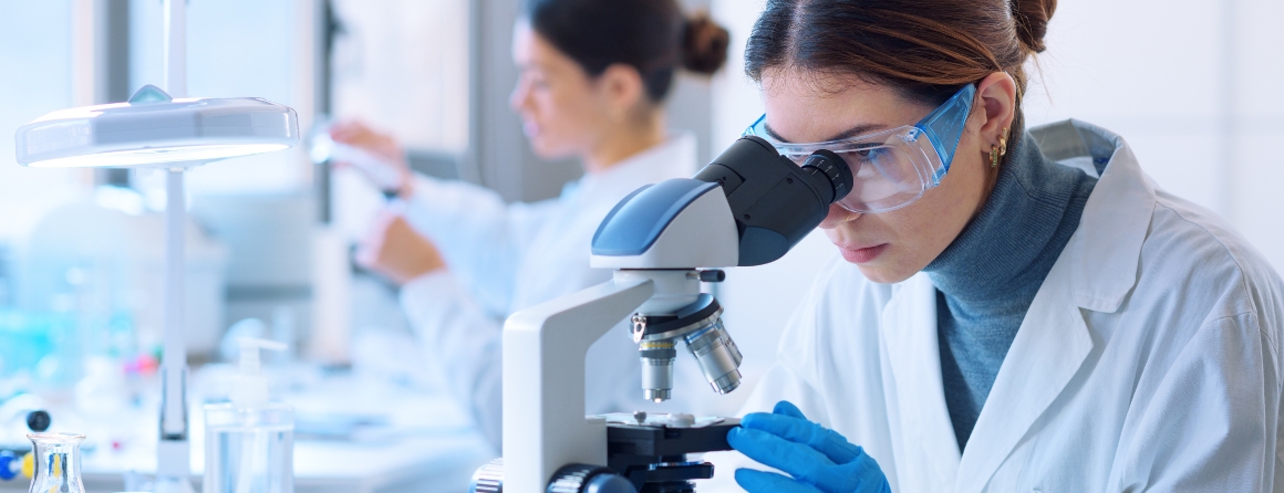 A researcher looks under a microscope
