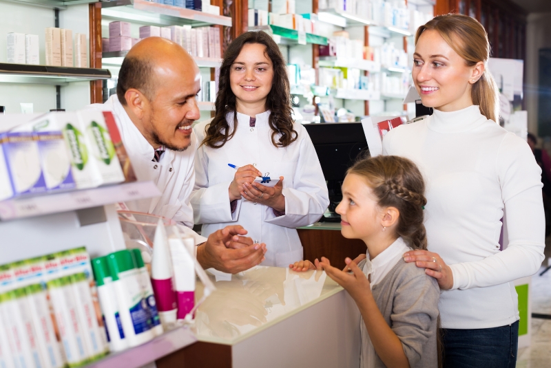 A pharmacist speaks with three children