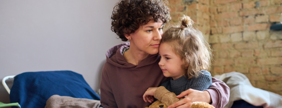 A worried parent with their child and a teddy
