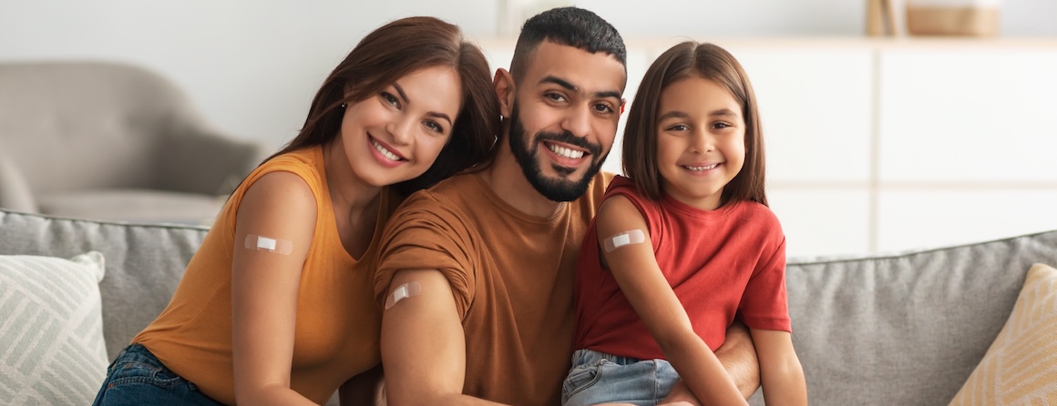 A mother, father, and daughter smiling post-vaccination