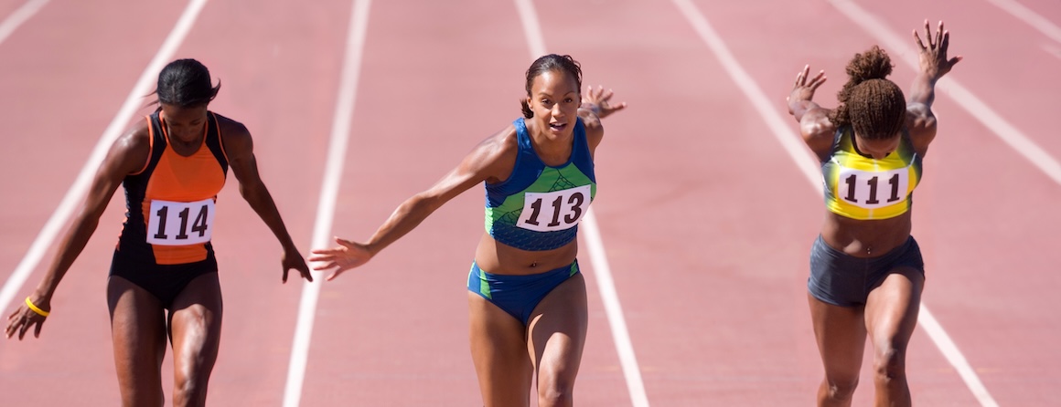 3 female athletes running on a track