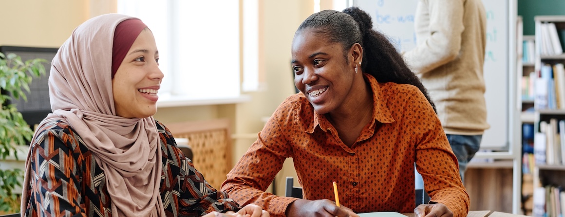 Two young women talking happily