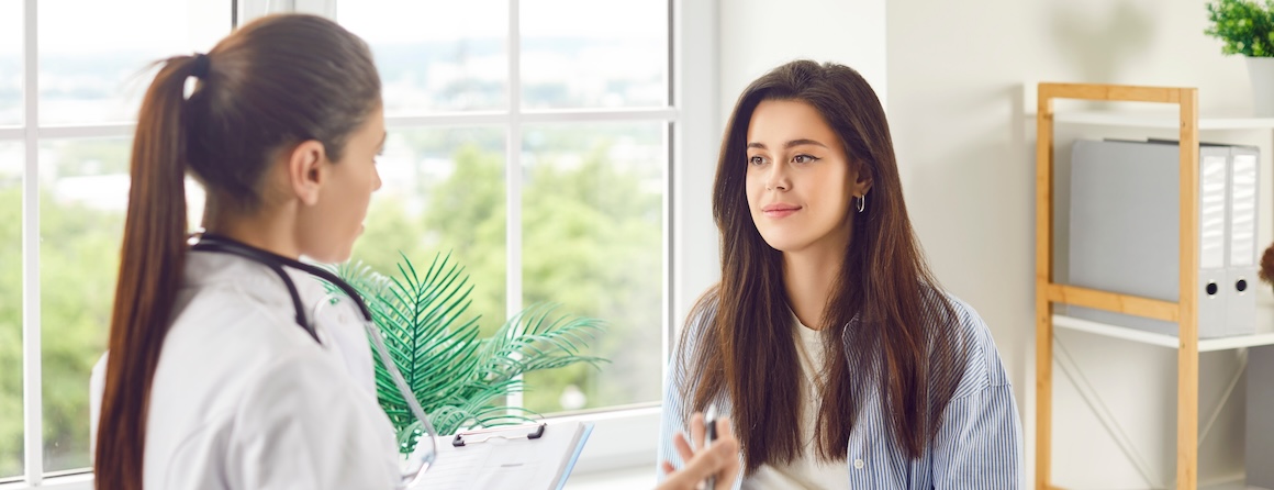 A doctor speaks with an adolescent woman early menopause
