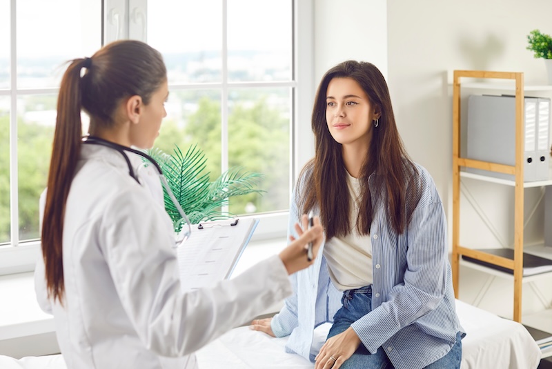 A doctor speaks with an adolescent woman about early menopause