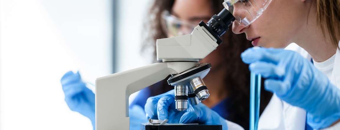 A researcher looking through a microscope