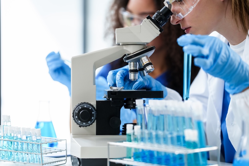 A researcher looking through a microscope