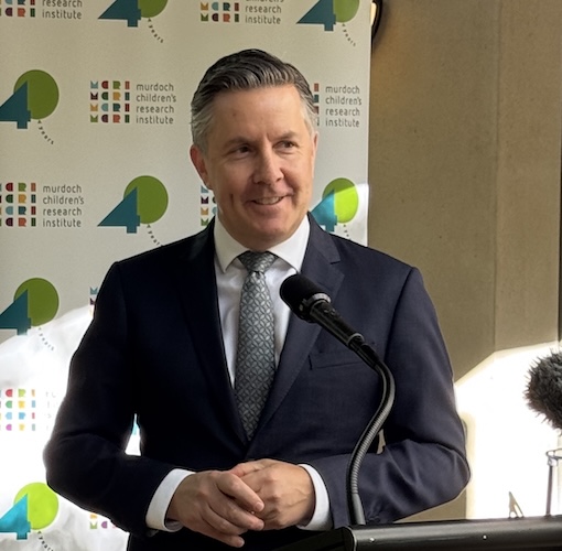 Federal Health Minister Mark Butler in front of the MCRI banner