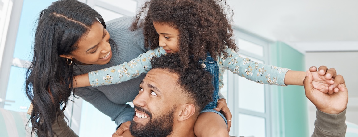 A family of four playing on a couch. Daughter, son, father, mother.
