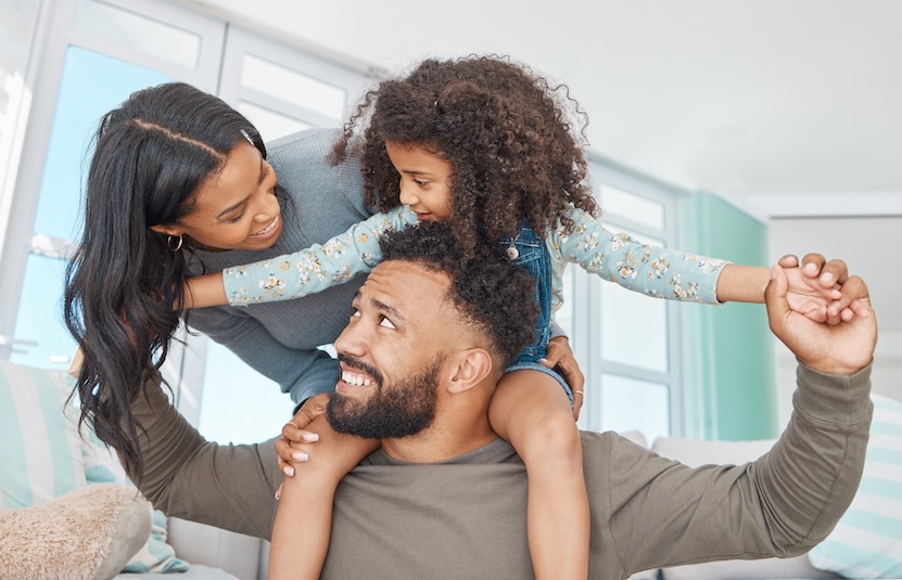 A family of four playing on a couch. Daughter, son, father, mother.
