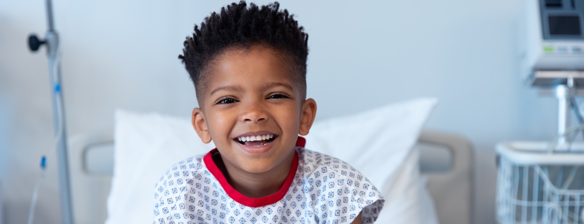 A child smiling in a hospital bed