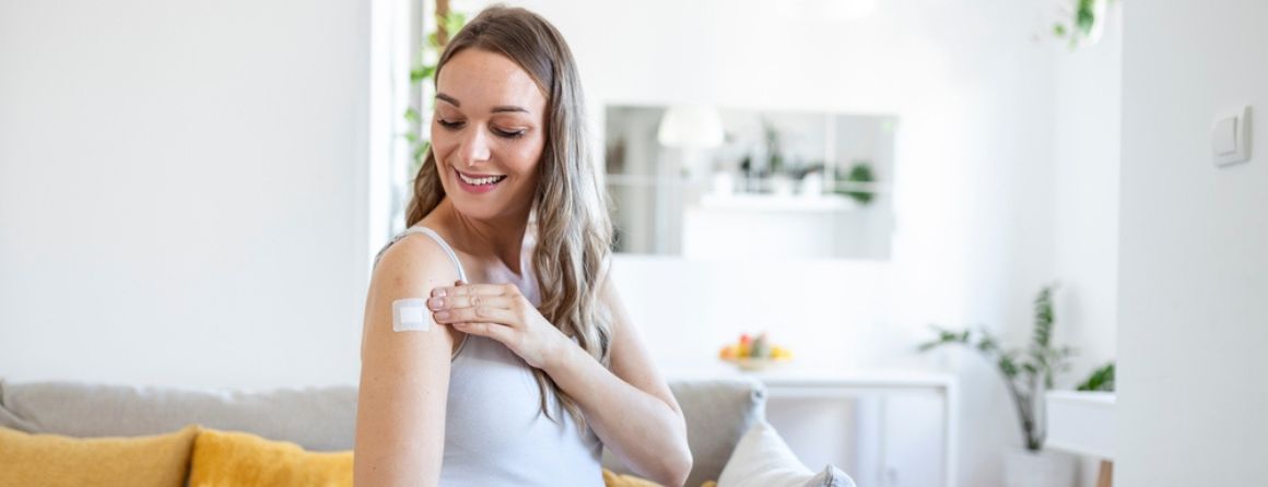 Pregnant female sitting on a couch after covid-19 vaccination
