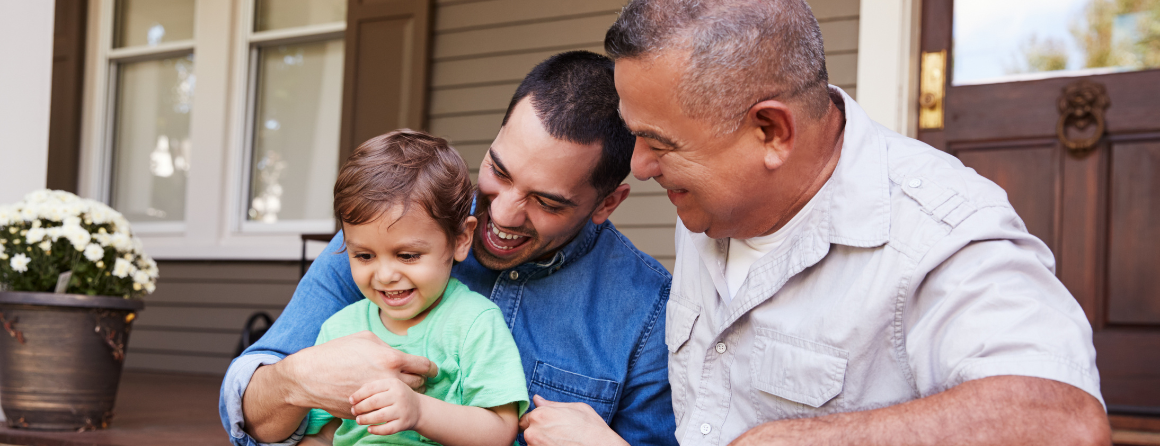 Multi Generation Family Sitting On Steps in Front Of House