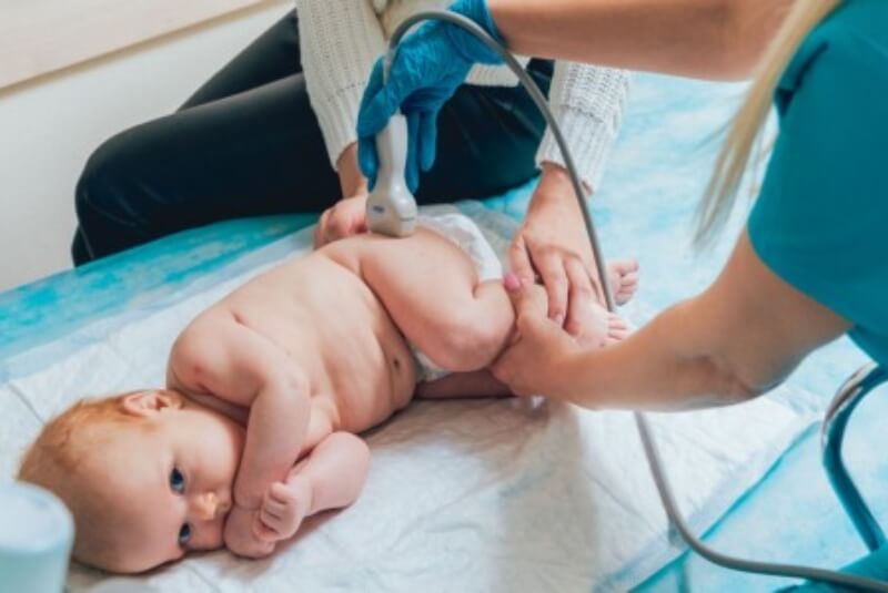 Infant having ultrasound performed on left hip.