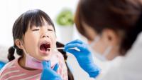 Doctor looking in child's throat