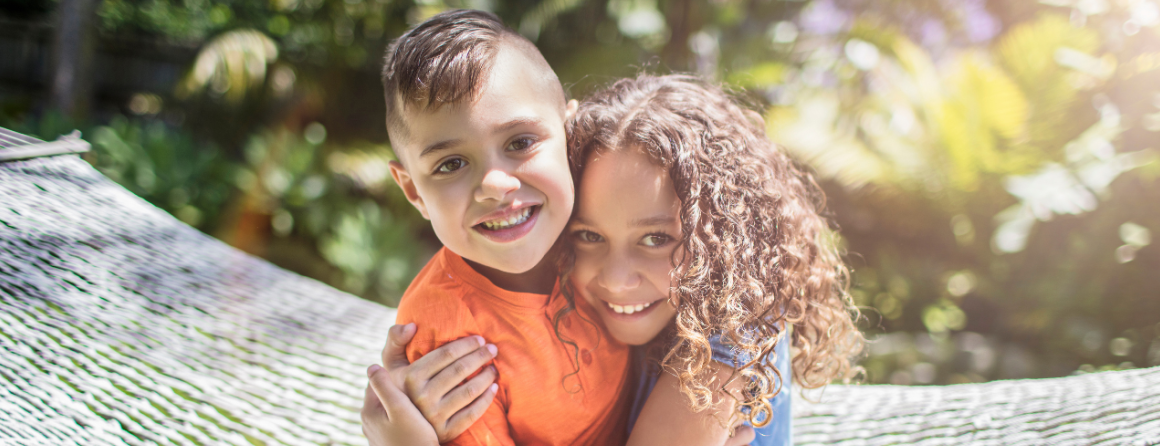 Two aboriginal children hugging and smiling 